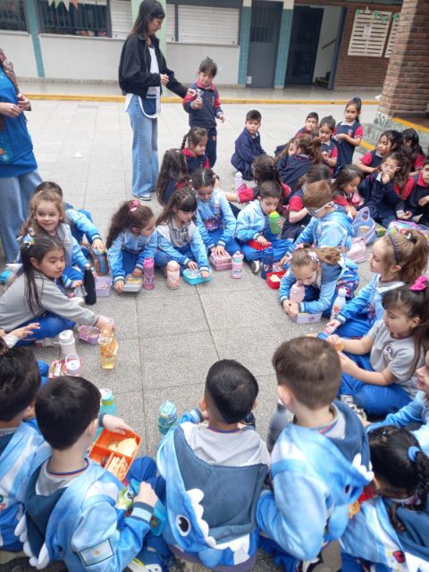 Los chicos meriendan en ronda en el patio del colegio